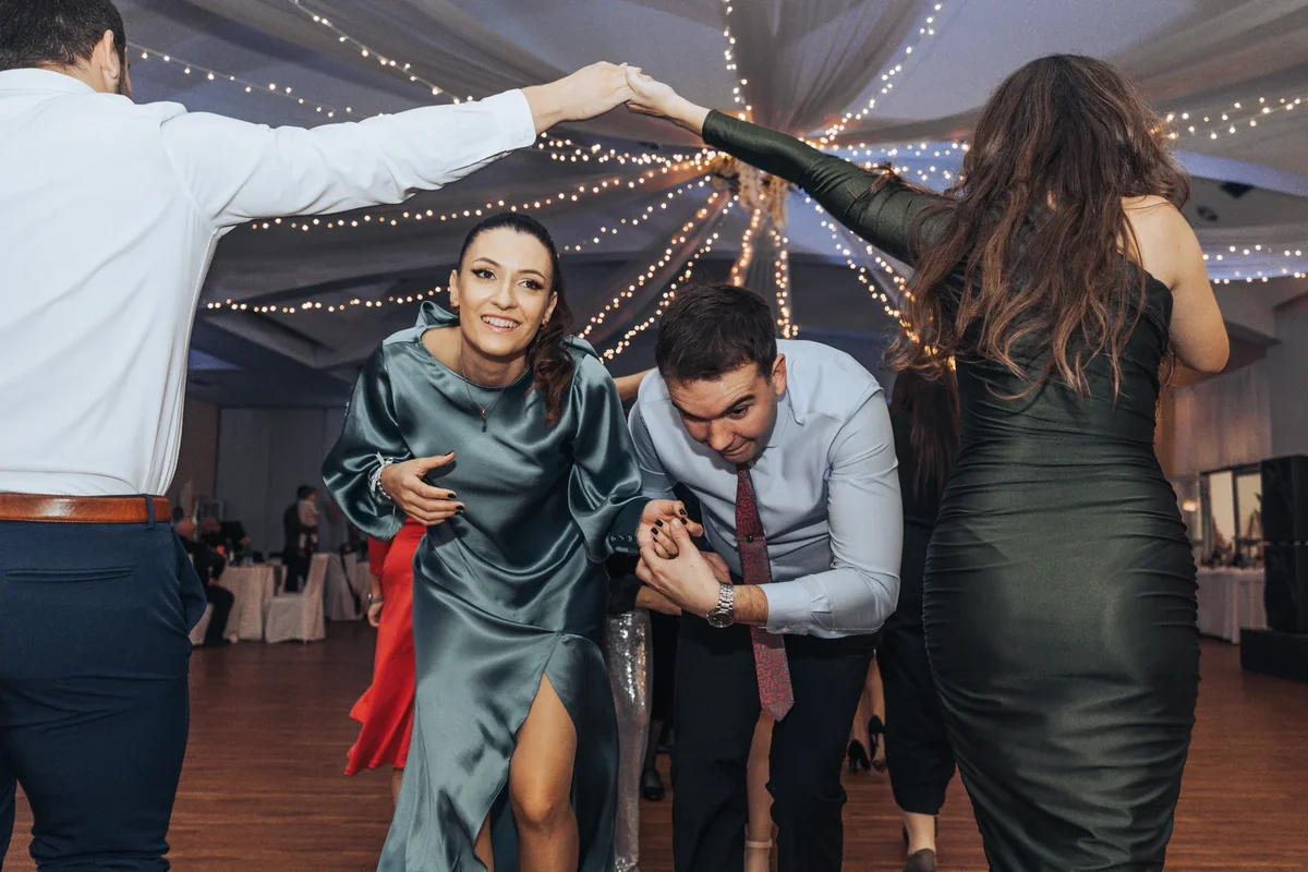 Veseli trenutak slavonskog svadbenog plesa s prolaskom ispod ruku u koloni.